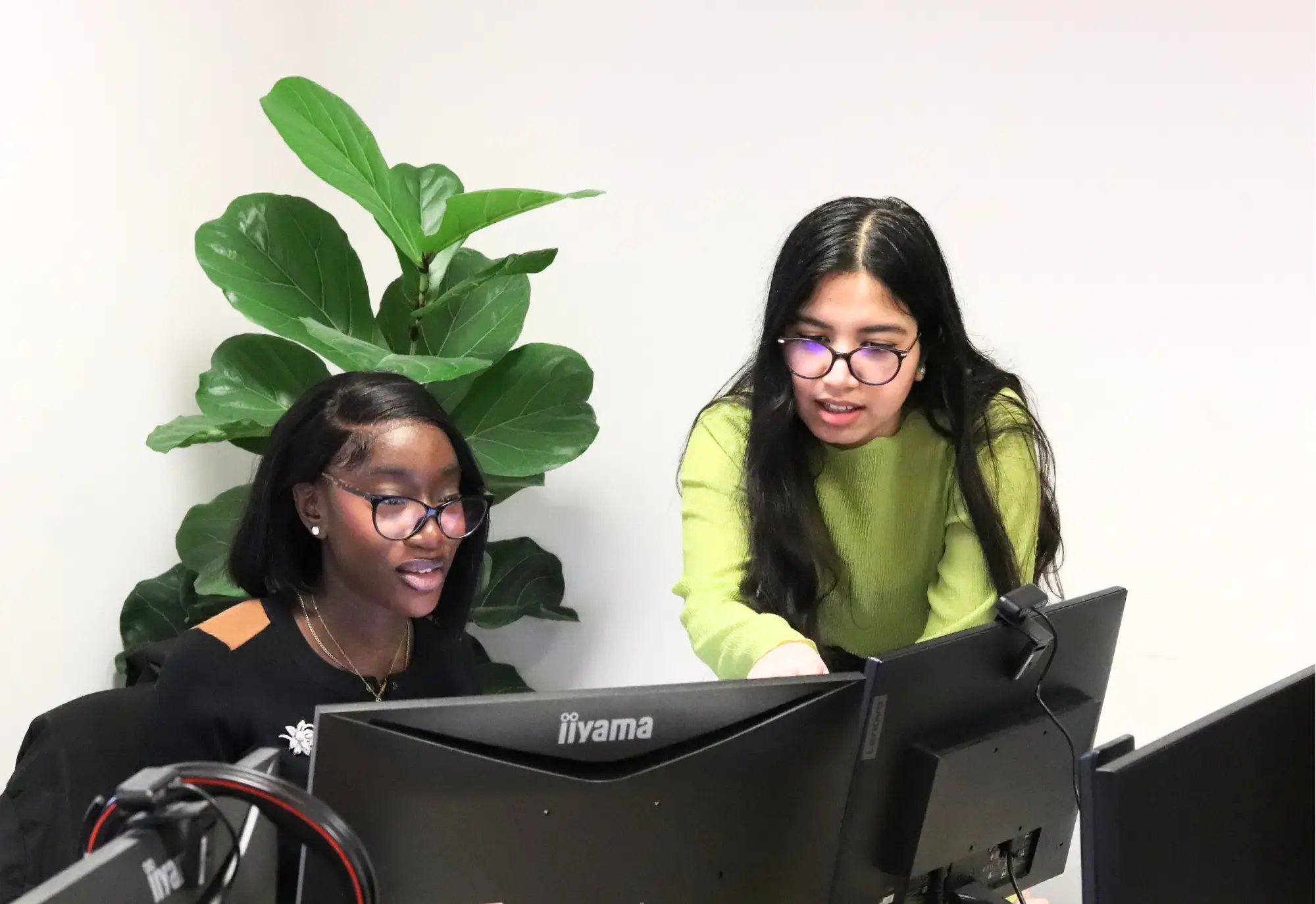 Chelsea and Ayesha looking at a clients logo design and branding