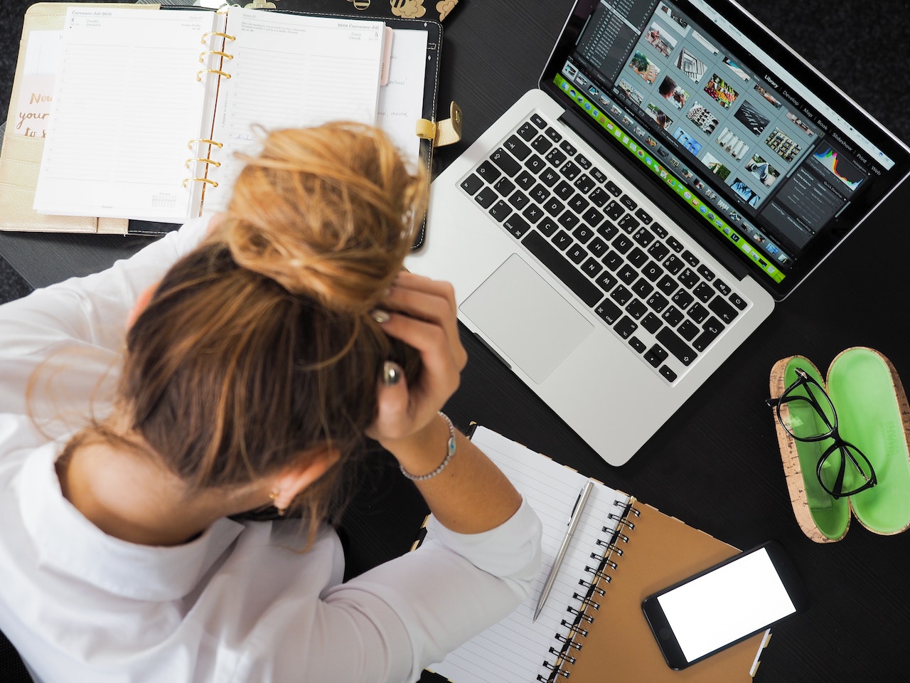 A businesswoman leaning over her laptop stressed as she doesn't have Hubspot CRM to help her small business