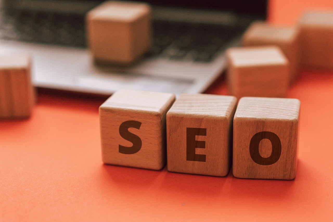 A business owner spelling out S E O on wooden blocks to help improve their online visibility and ranking