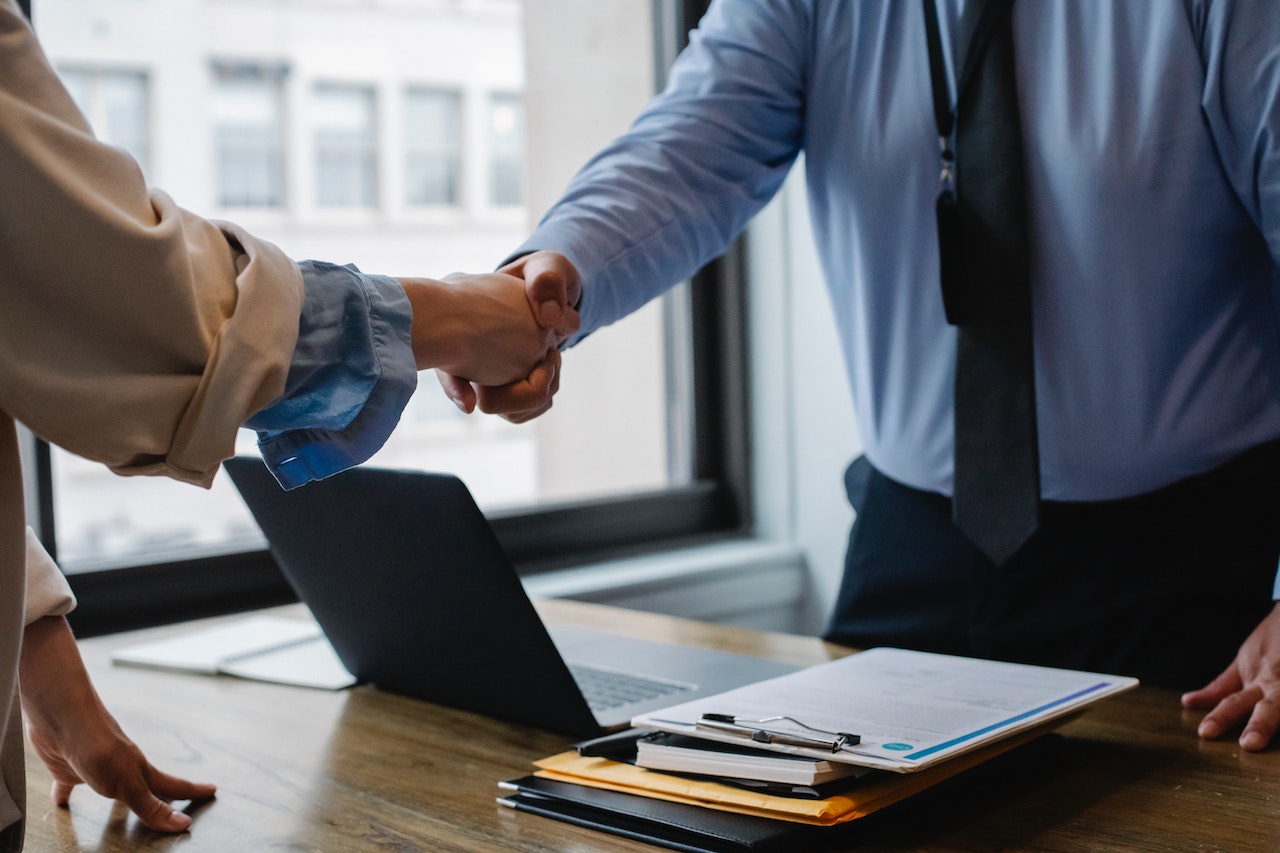 A salesman with a strong sales culture shaking hands with a customer as they close a deal