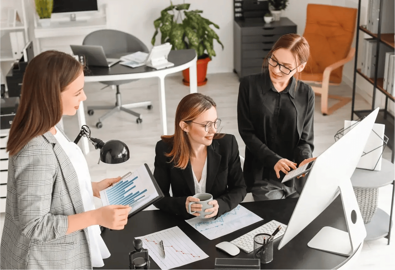 A group of three accountants discuss a client's financial situation. 