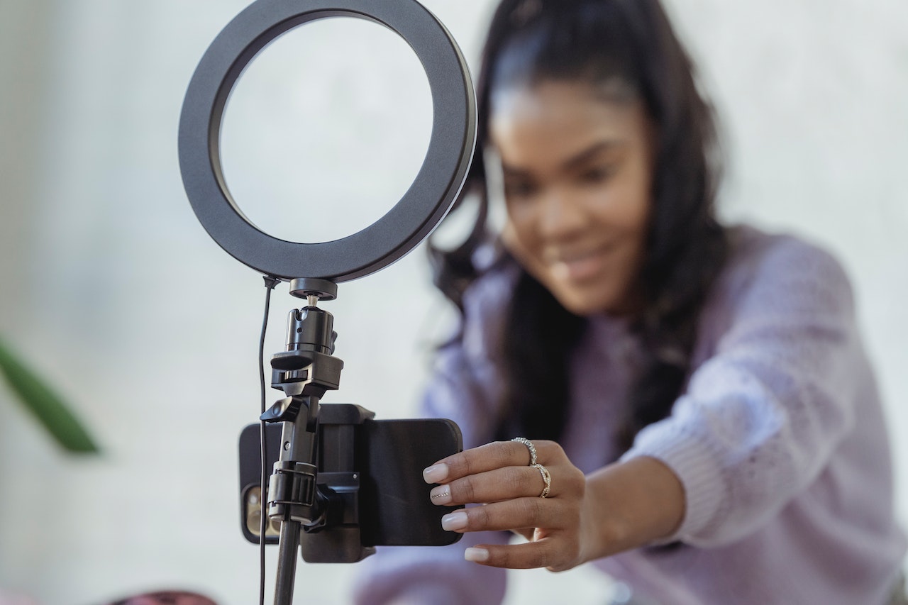 A small business owner excitedly setting up her phone and ring light to start creating an Instagram reel