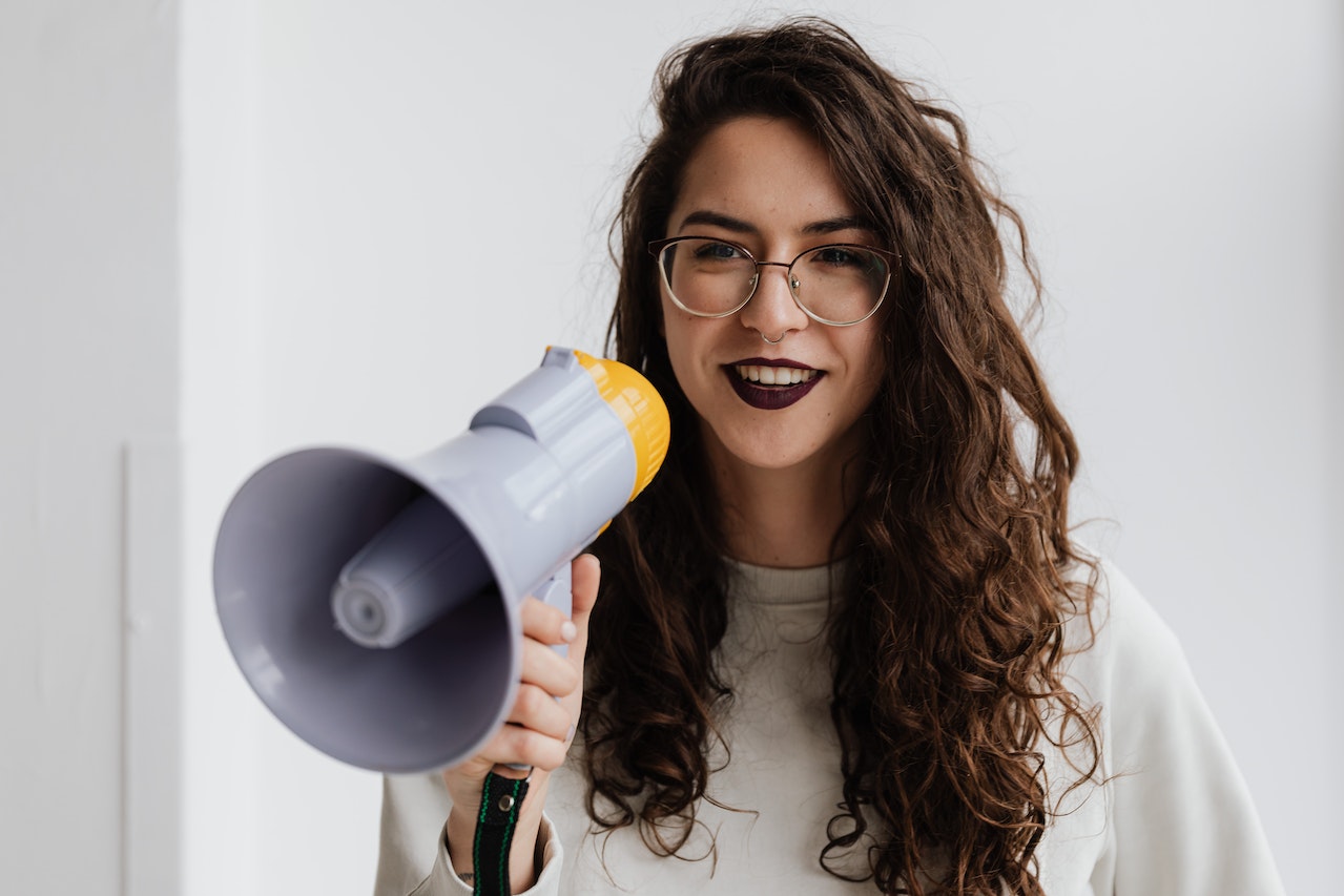 A business woman with standing with a megaphone using calls to actions effectively and generating leads through them