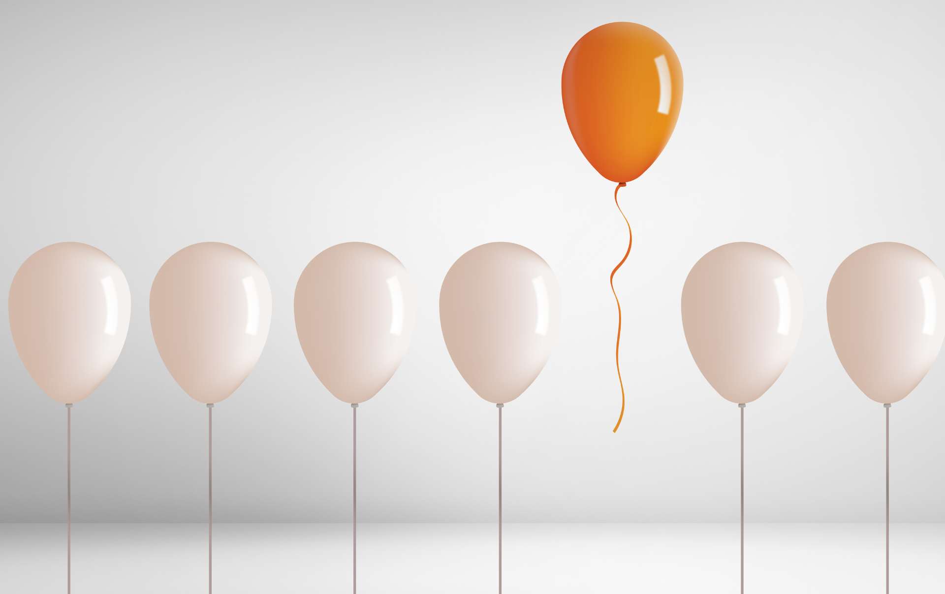 An orange balloon floating above a line of white balloon just like a small business which is standing out due to using inbound and automation marketing