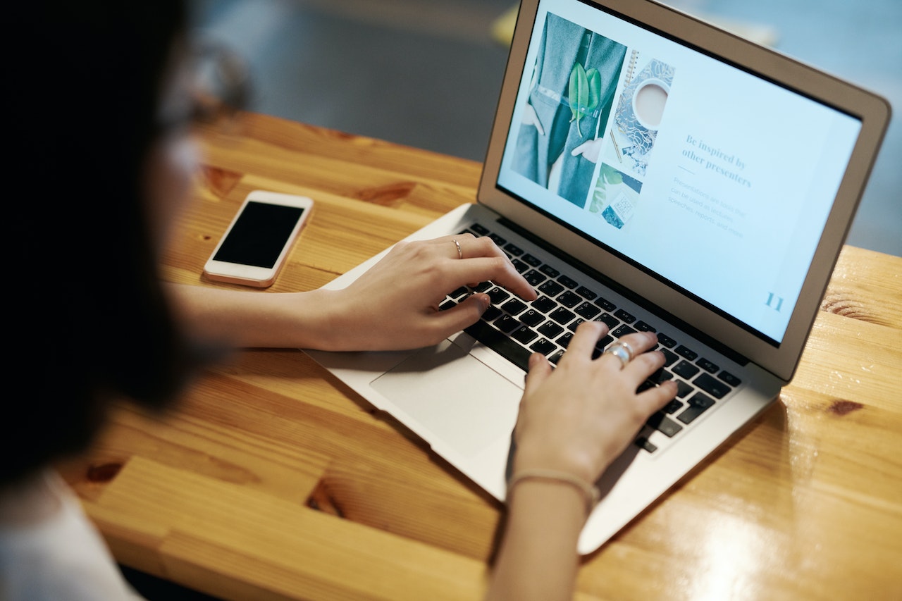 A women creating a blog article on her laptop to use in her content marketing for her business