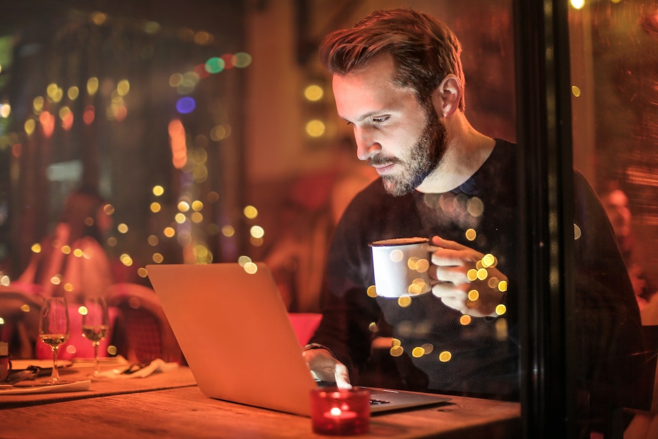 A small business owner sitting at his laptop with a coffee, searching how to get starting with inbound marketing