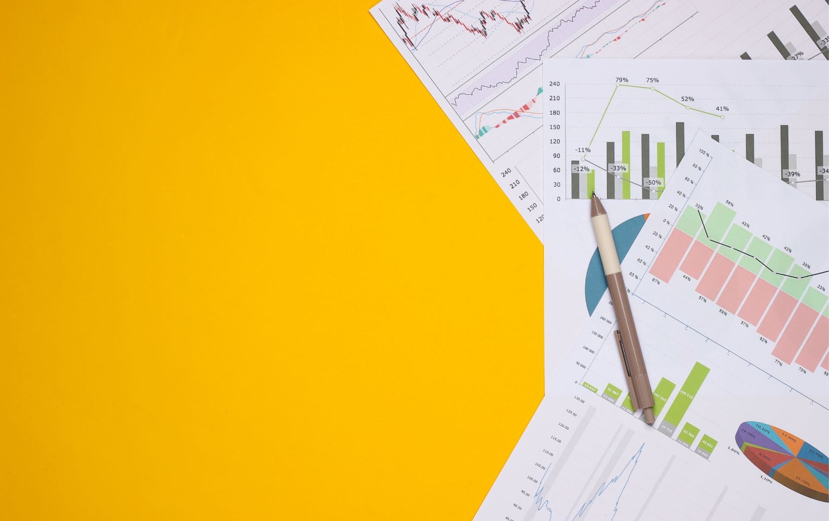 Three pages scattered on an orange desk printed with a business owner's Google analytics reports showing how sales have increased with the pages having pen resting on top 