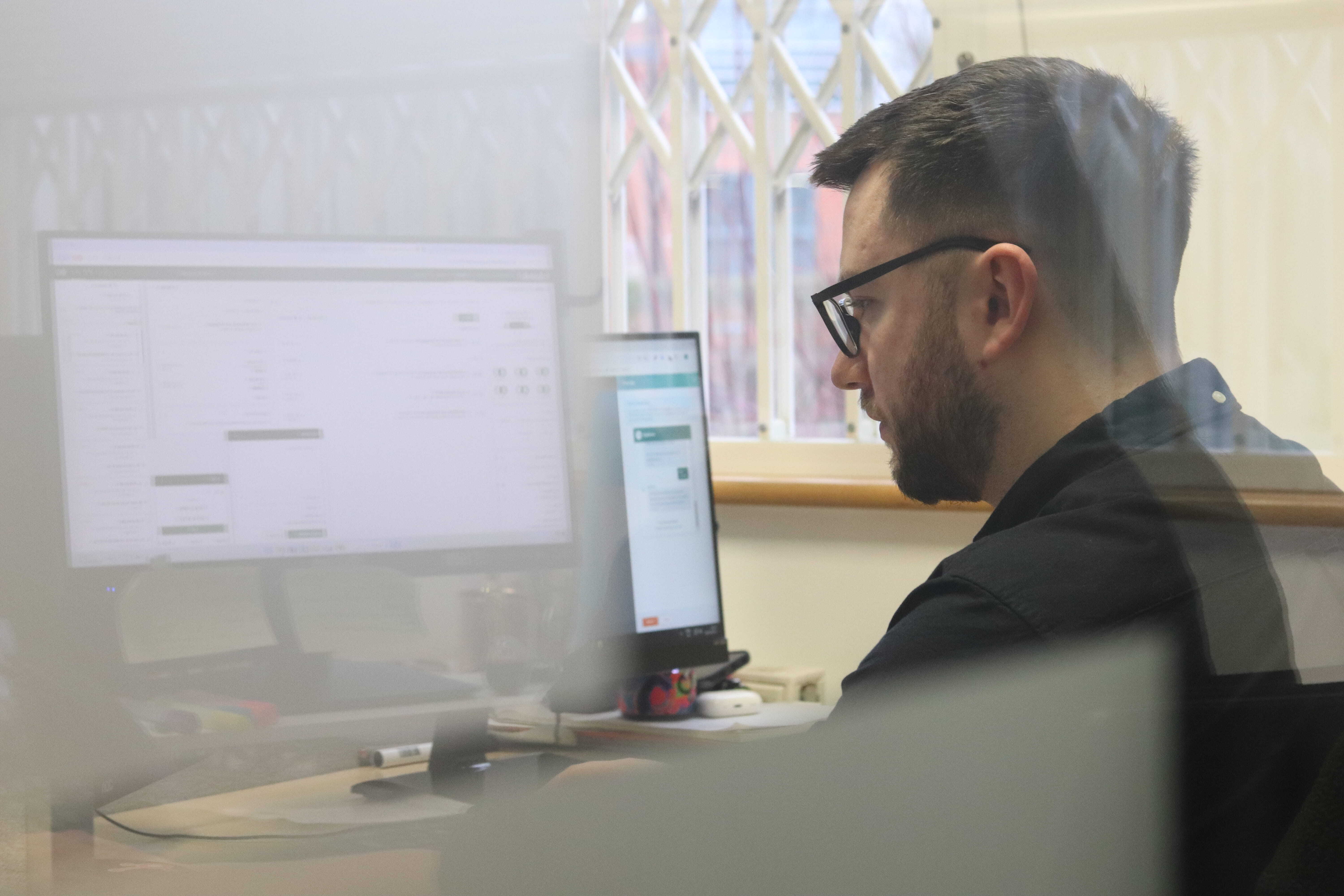 James focusing intently on his computer screen with his glasses on, researching gdpr and cold data.