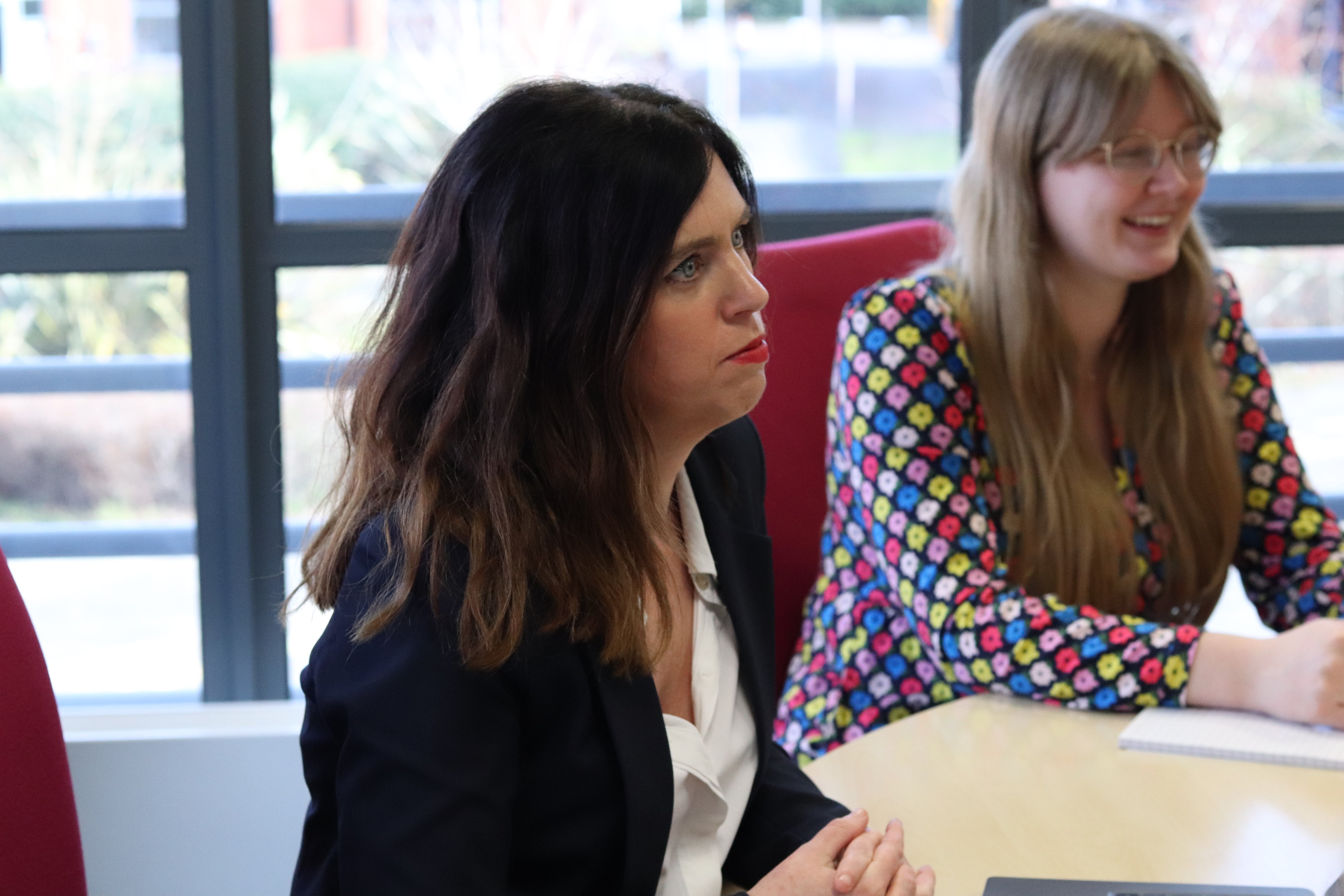 Shirley and Emma concentrating during a marketing meeting.
