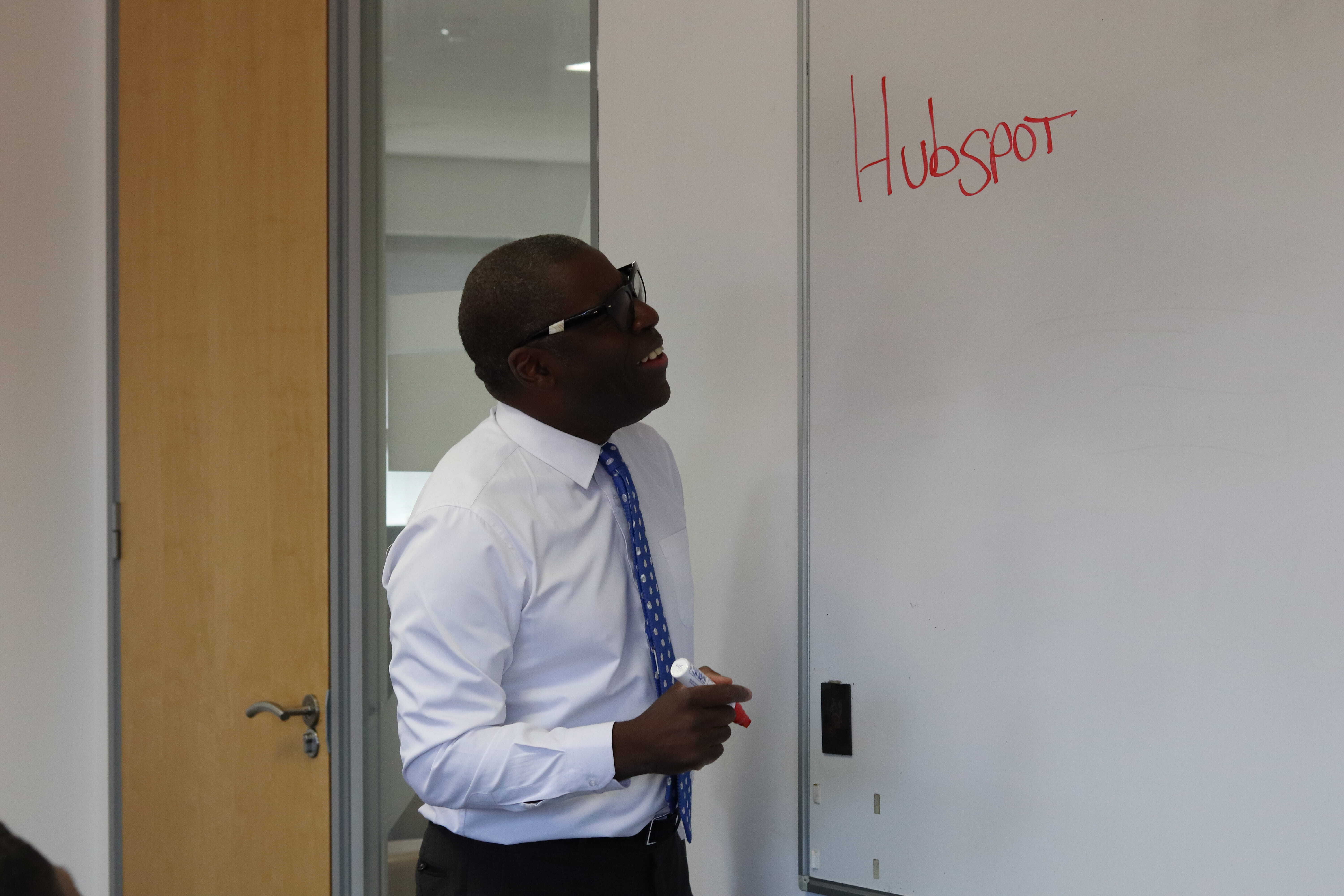 Dave, one of our directors, in front of a whiteboard which has 'Hubspot' written on it.