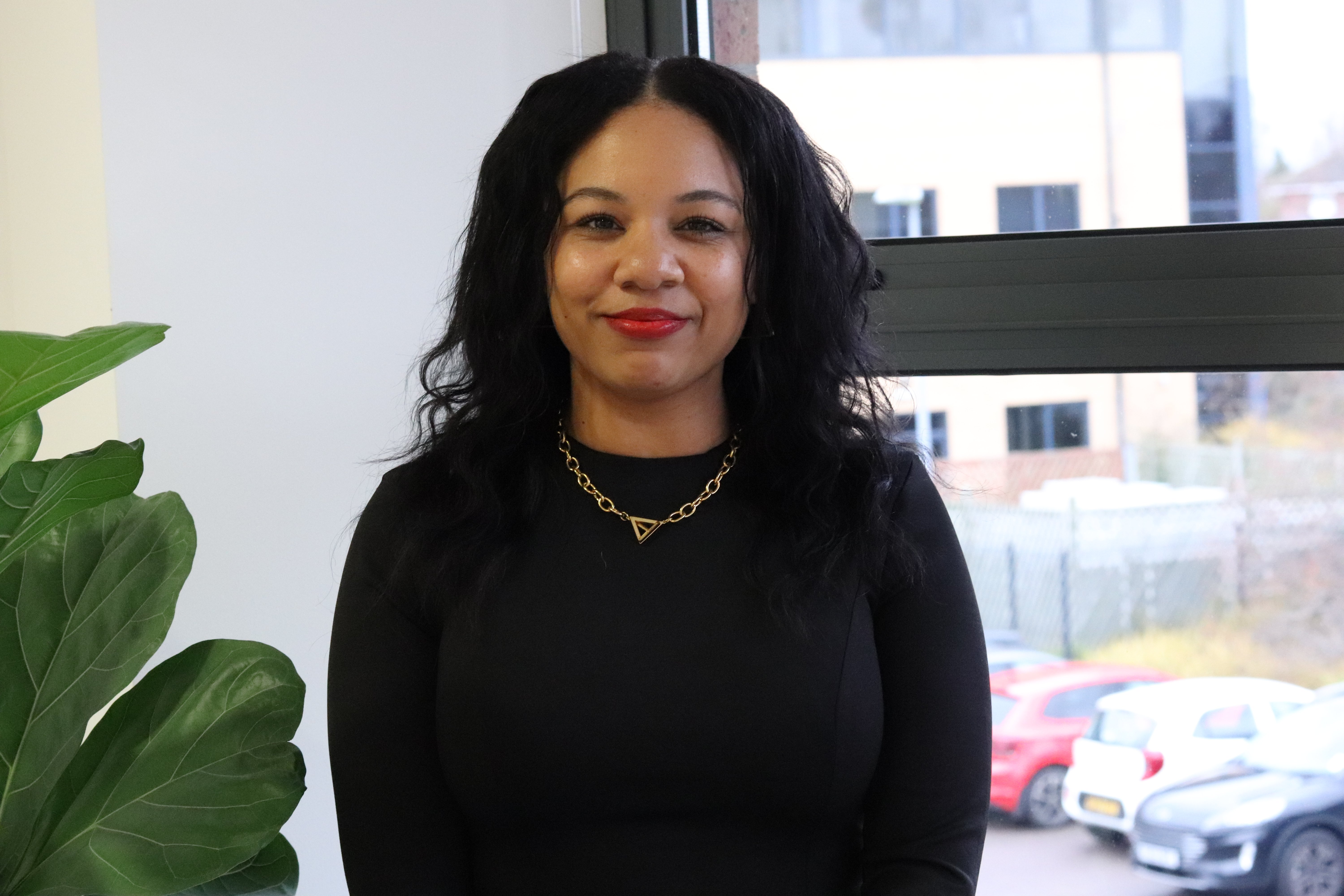 Kerry, who delivers social media marketing strategies, standing in the meeting room and smiling.