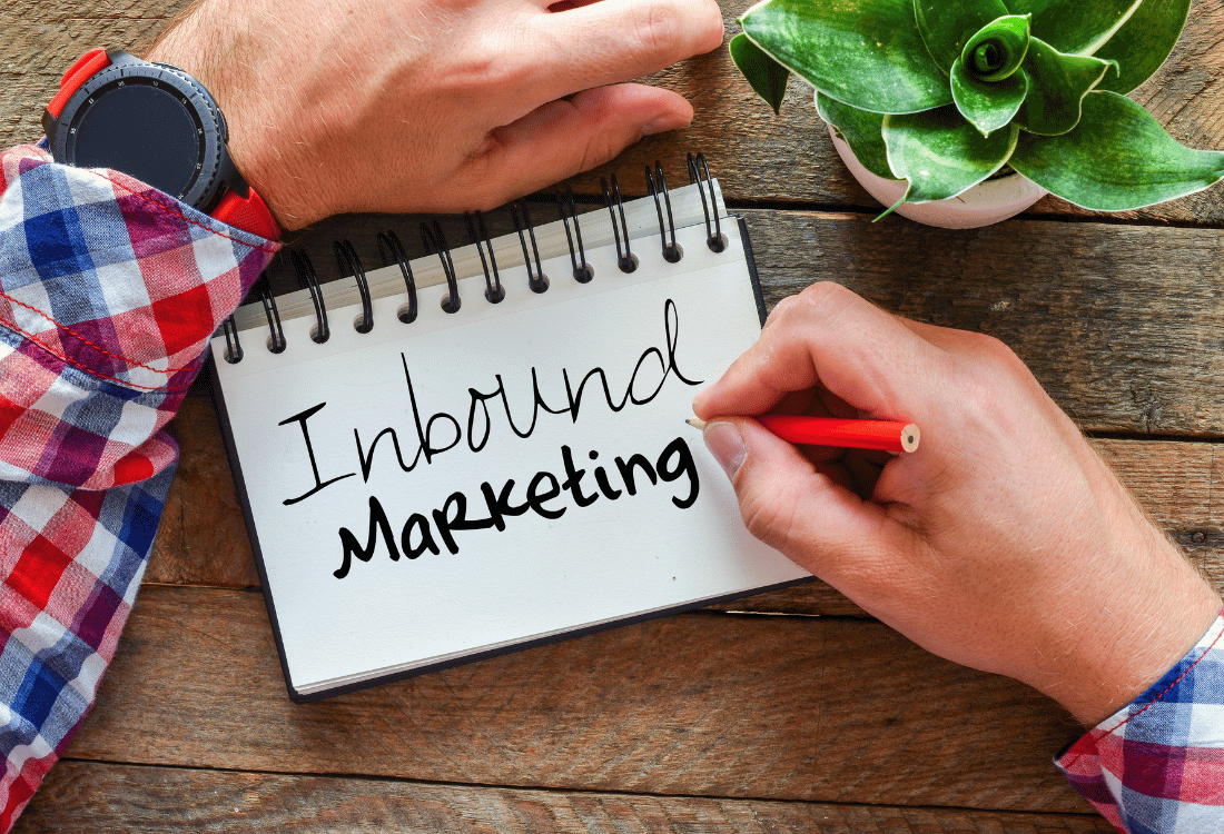 A man writing the word inbound marketing onto a notepad.
