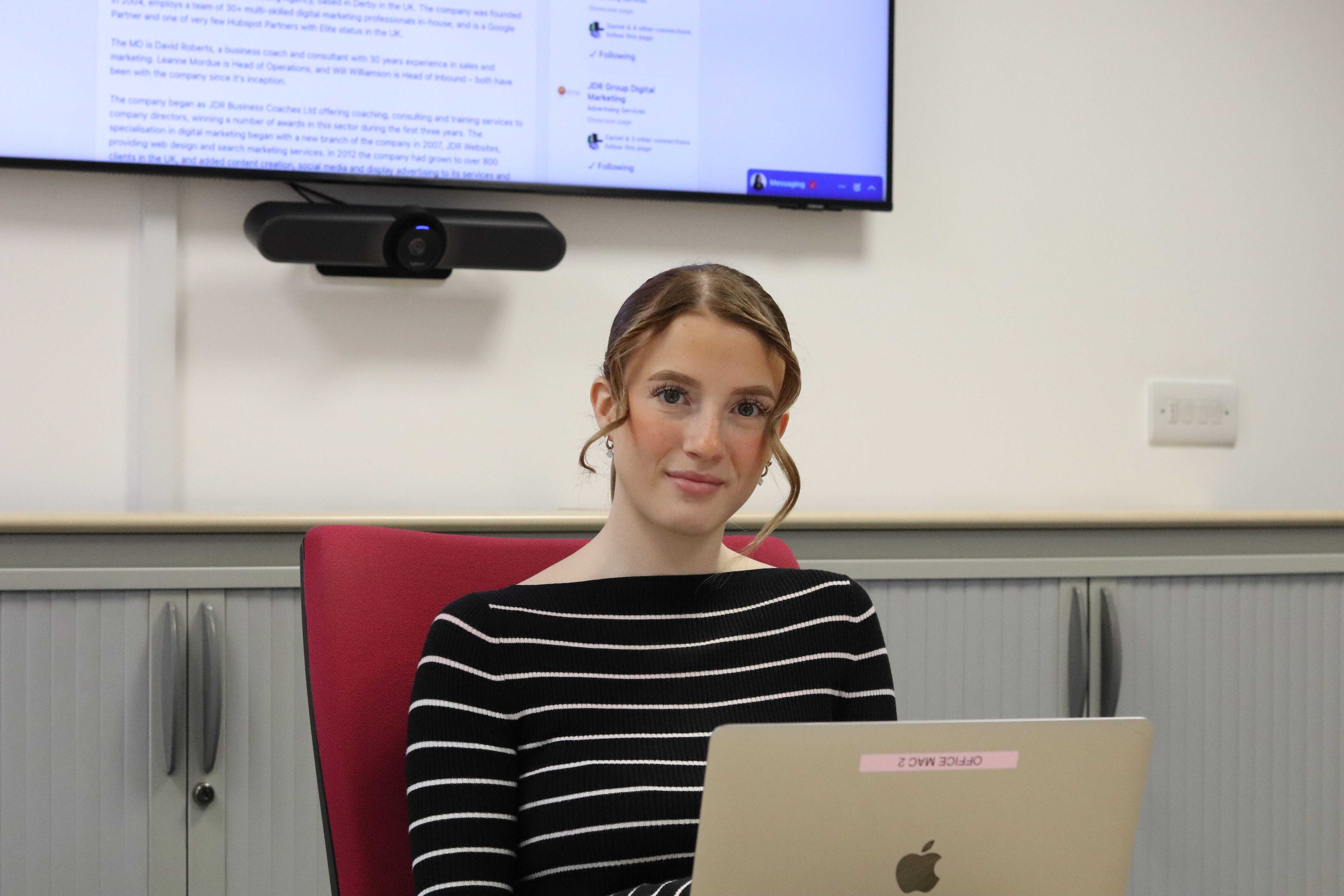 Ellie smiling with her laptop open during a meeting about the 2026 LinkedIn algorithm update.