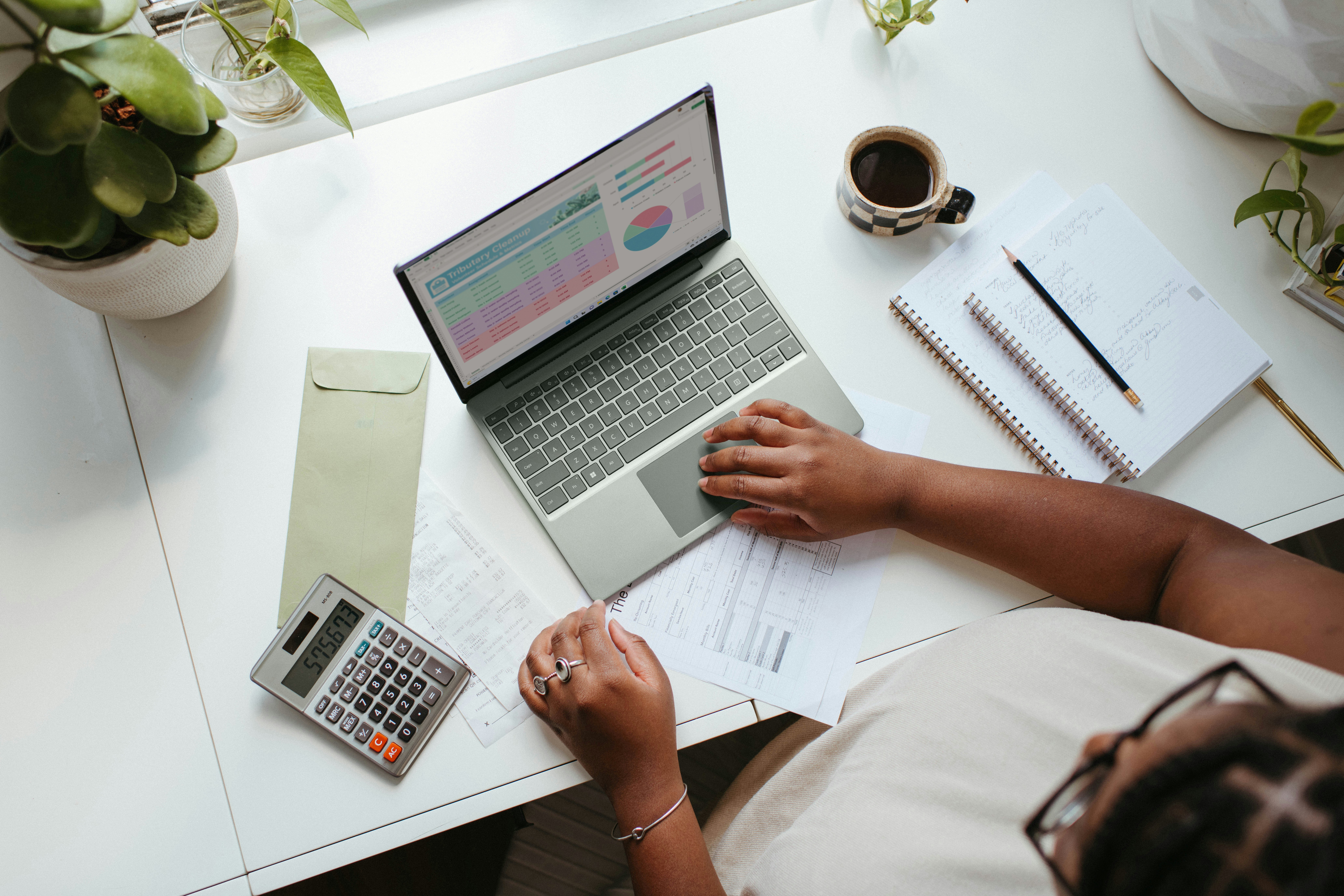 An individual using her laptop to make strategic moves for maximising her business value.