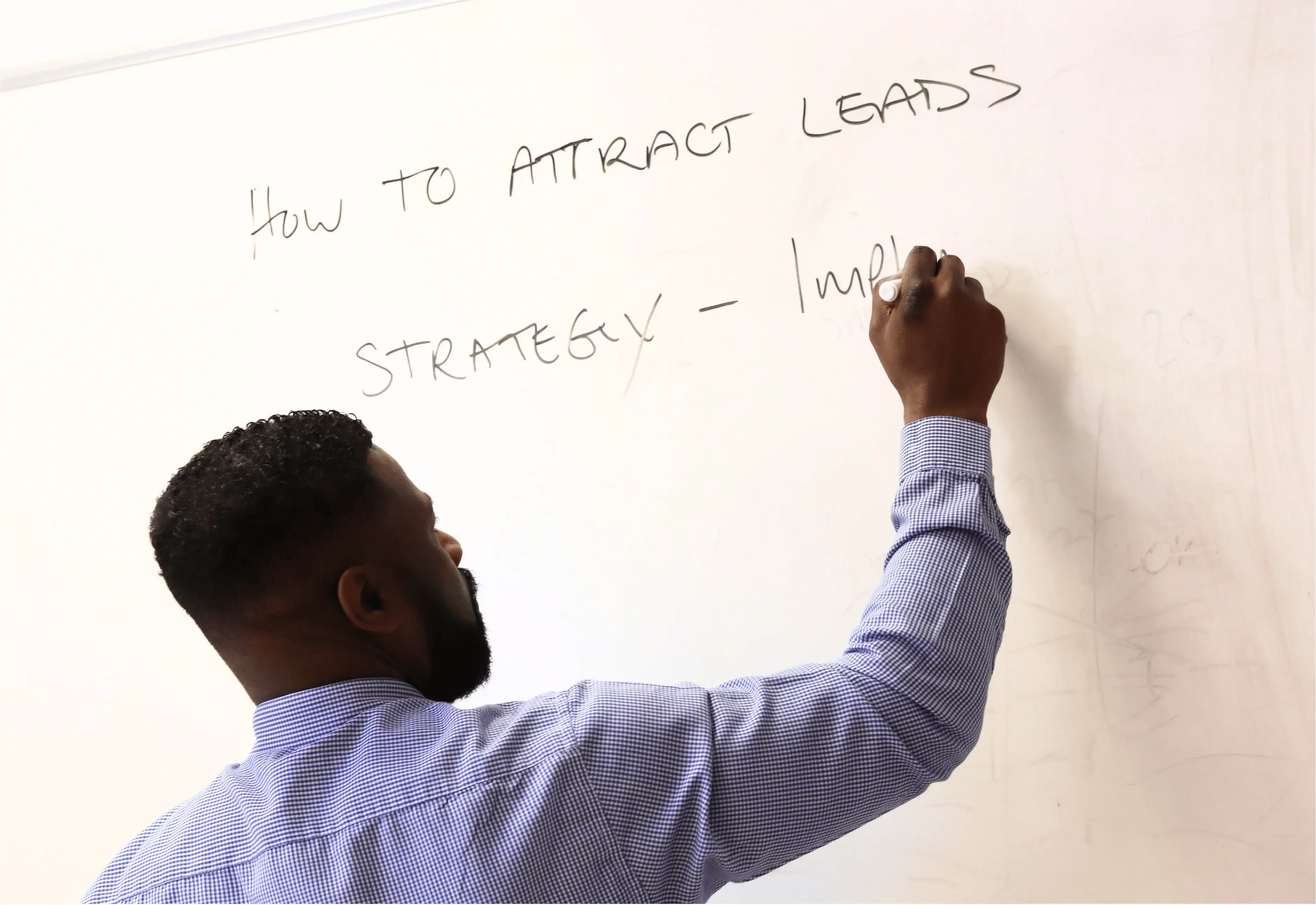 Dan writing on a whiteboard how to attract leads through brand strategy