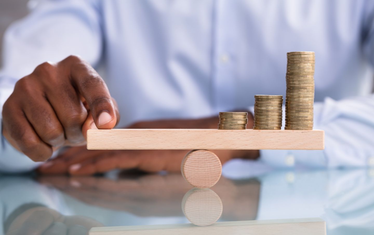 A business owner balancing his Salesforce investment on a wooden beam with his finger resting on the other as he debates using Salesforce as his small business CRM after finding out about the software price increase