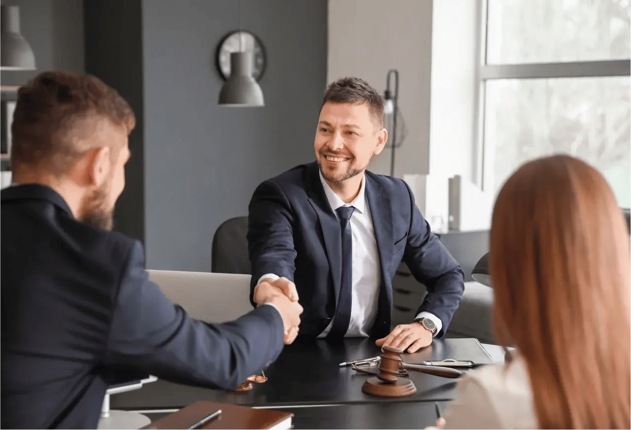 A solicitor shakes hands with a happy customer.