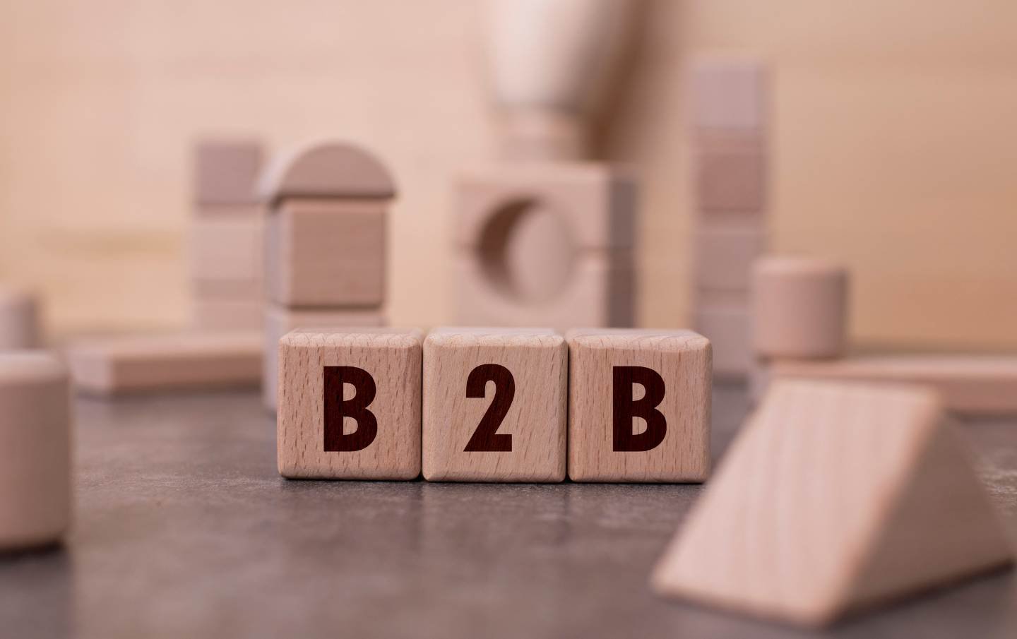 A set of three building blocks spelling out B 2 B that belong to a business owner who is driving sales to their business