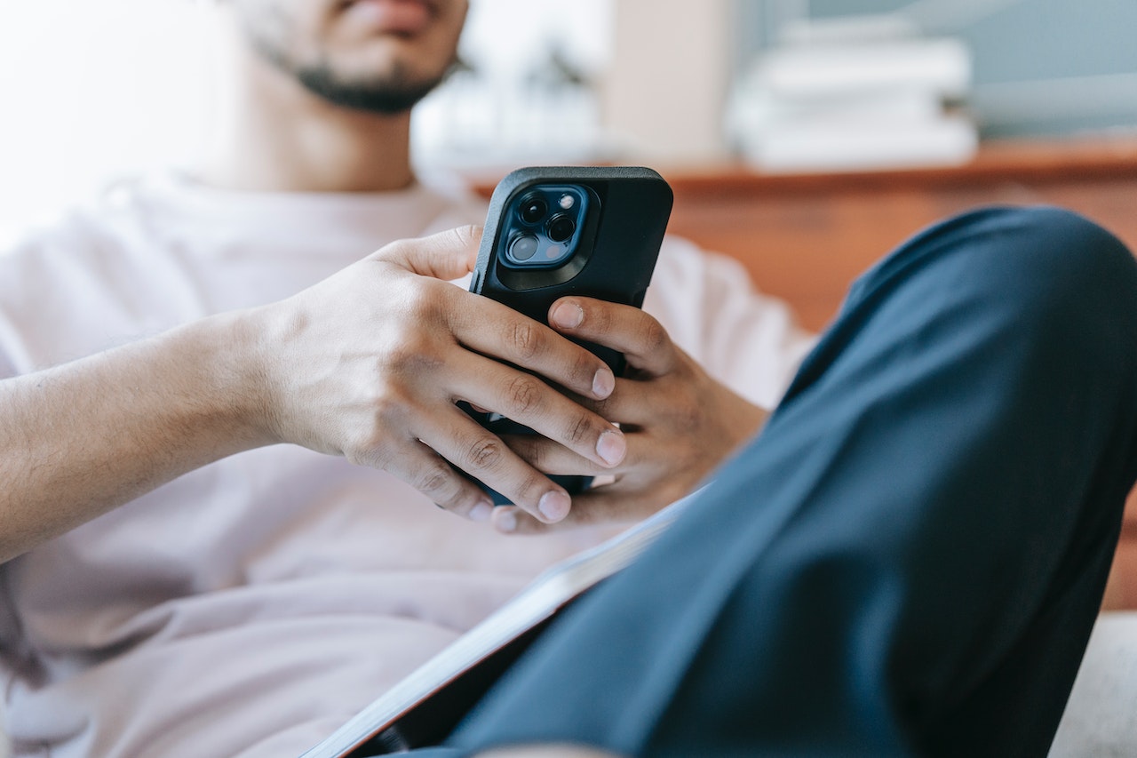 A man on his phone checking his followers on LinkedIn using the platform's new LinkedIn analytics tools