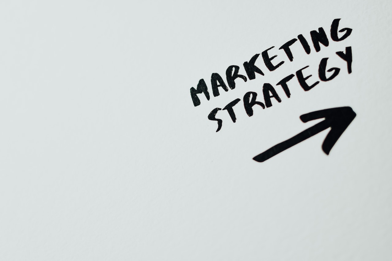 Marketing Strategy underlined with an arrow pointing towards the top right written in pen on a whiteboard by a small business owner with effective website lead generation strategies to increase their business' conversion rates