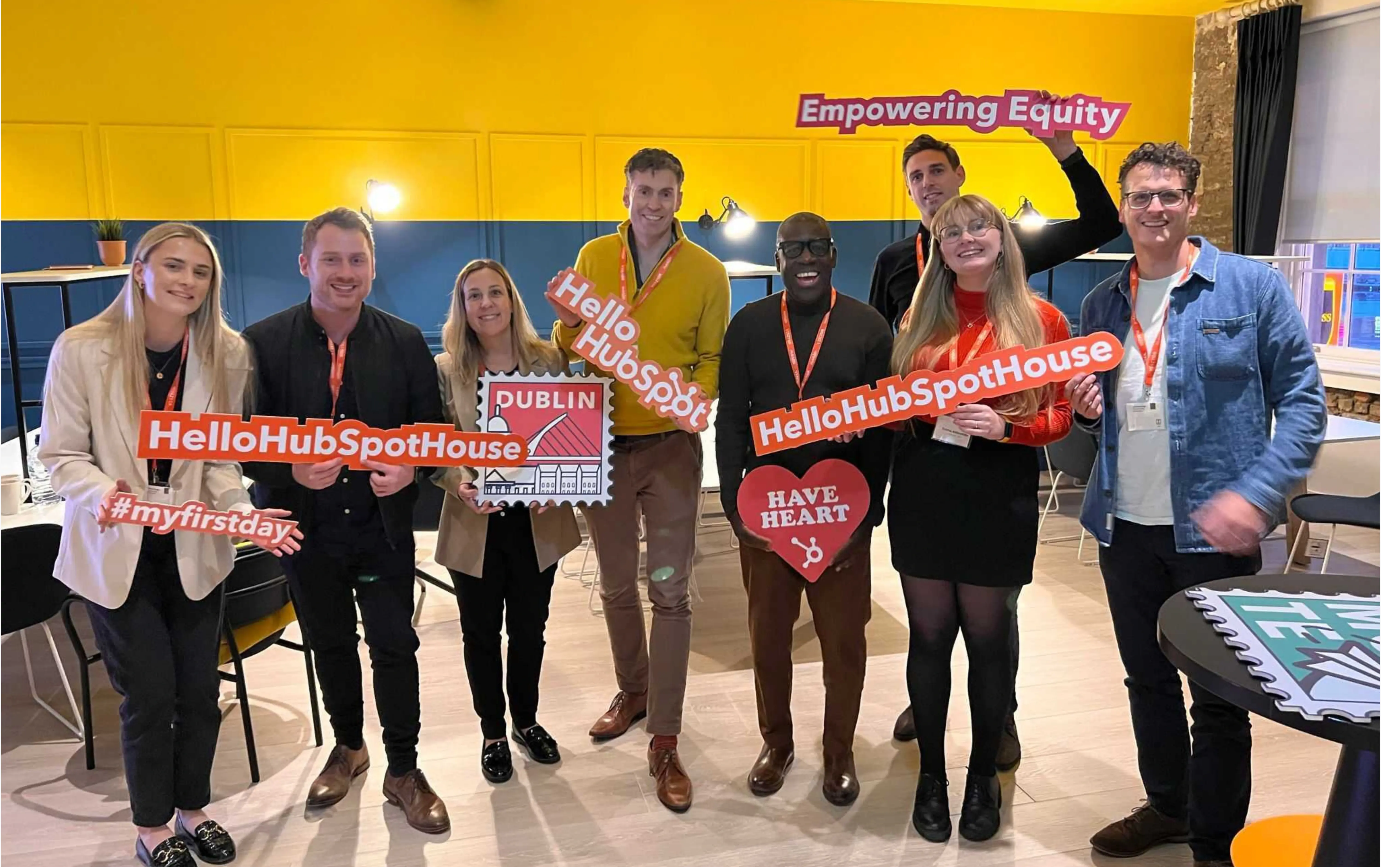 JDR Group team attending a HubSpot event, standing together and holding Hello HubSpot House signs, celebrating learning and innovation in customer service automation.