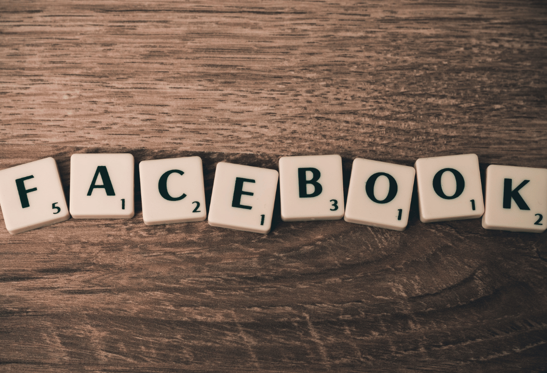Facebook spelled out using toy letters on a wooden table.