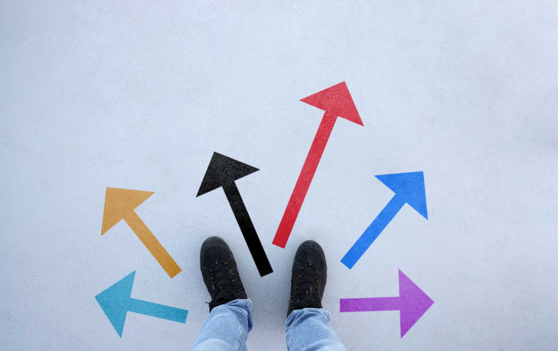 A business standing surrounded by arrows all pointing towards different ways of using marketing and sales confusing him and his business strategy