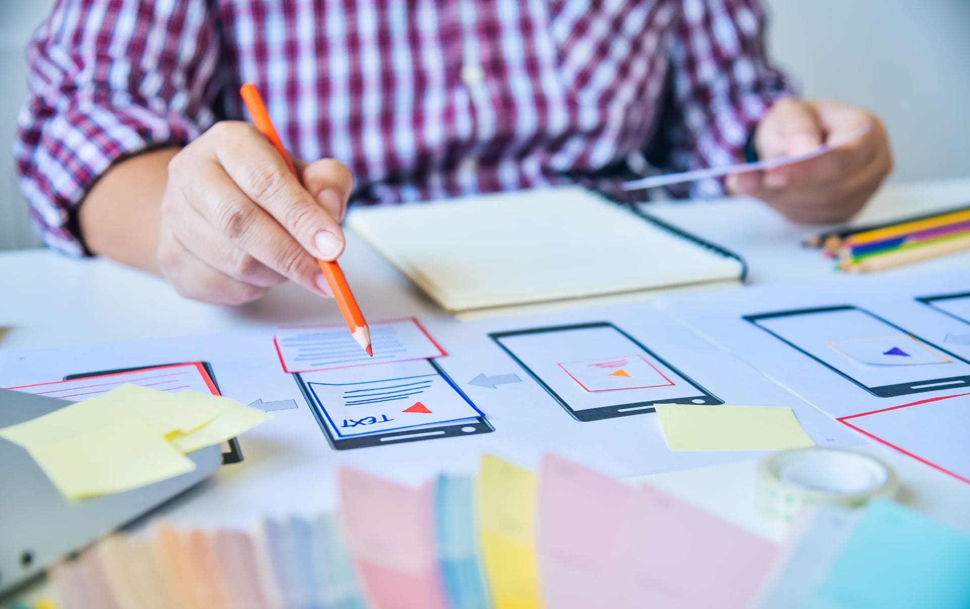 A business owner sitting at his desk looking through colour palettes and mood boards as he works out the structure for his new ecommerce website on Shopify.