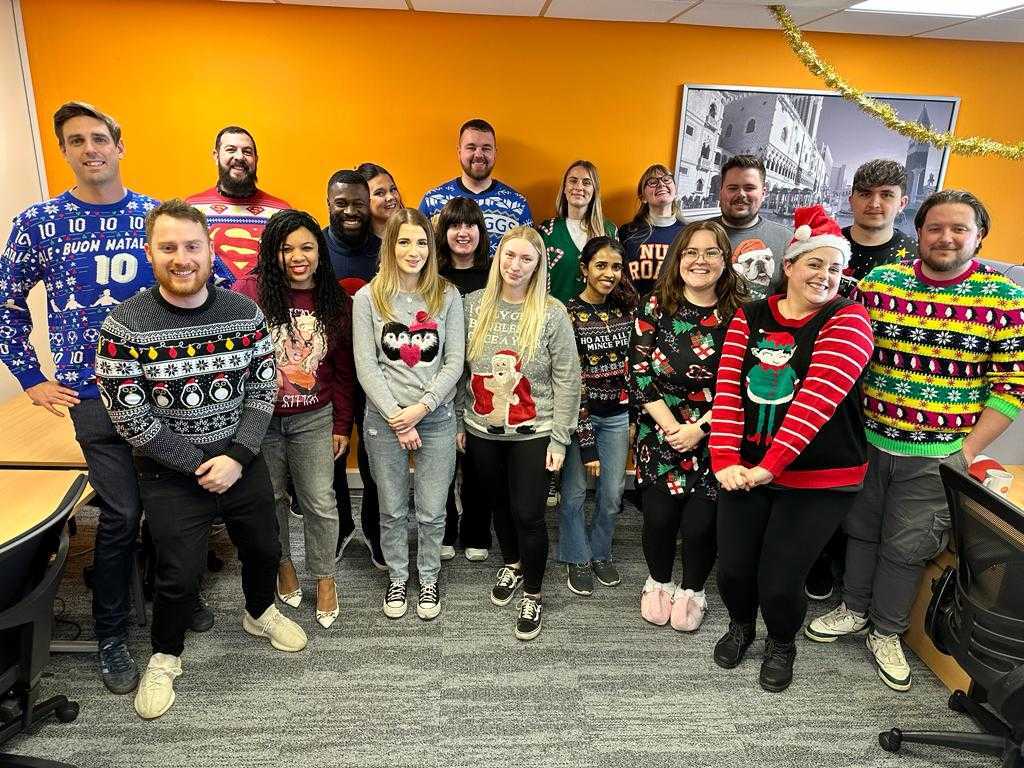 The JDR team standing together wearing Christmas themed attire for Christmas Jumper Day