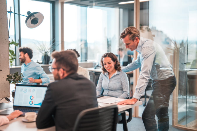 A business owner helping a colleague to how a HubSpot partner agency can help aswell.