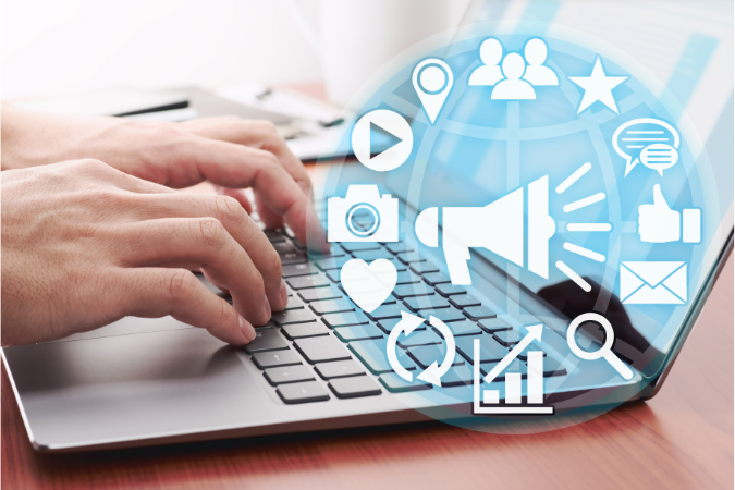 A user on their laptop with digital marketing graphics to show whether in-house or outsourced marketing is best for their business