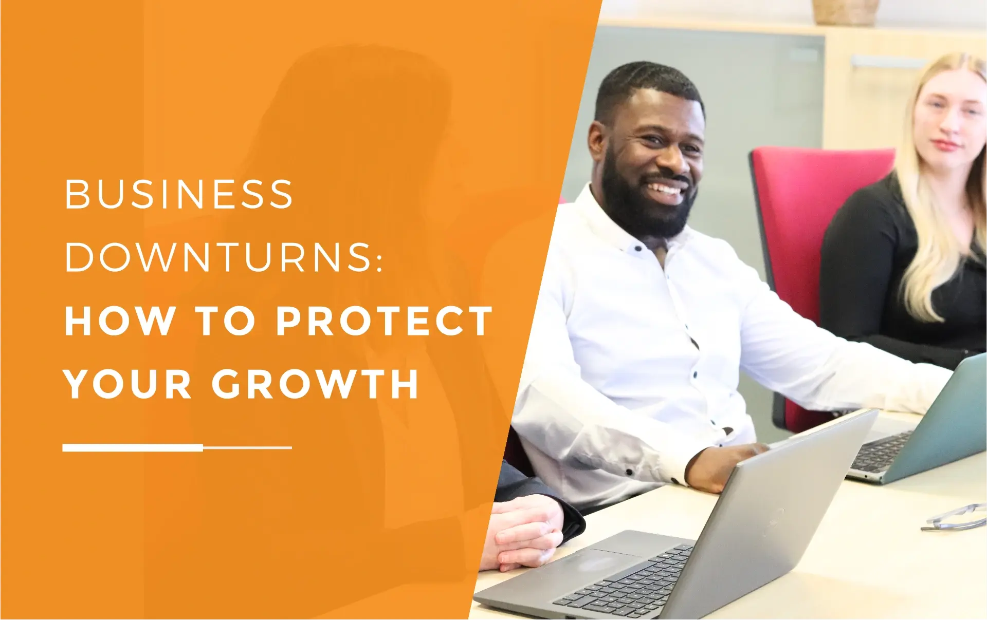 Dan and Amber smiling in a meeting with laptops in front of them, discussing how to manage a business downturn.