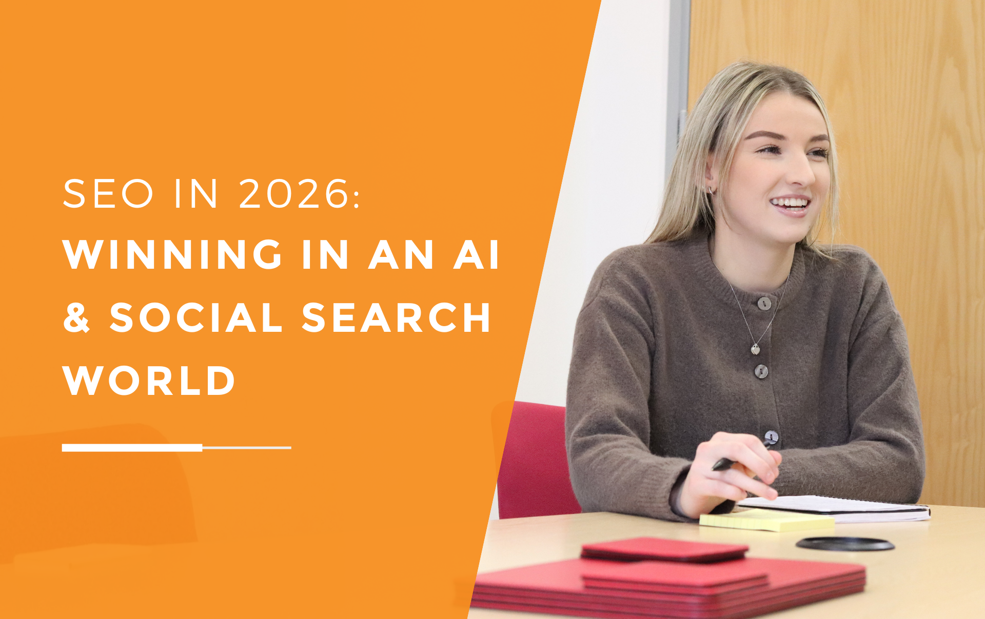 Emily leading a marketing meeting, smiling while taking notes at a conference table during a strategy discussion on SEO and digital visibility.